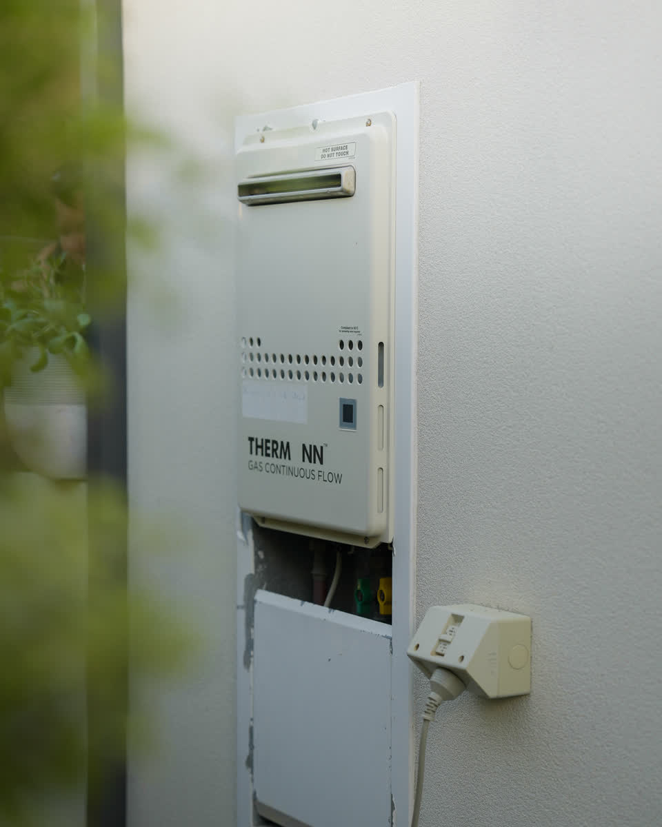 A continuous flow hot water unit on an outside wall